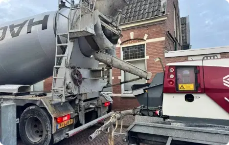 Betonwagen van Hagen met een betonpomp van Cazant er achter bij een klus van goedkoopbetonbestellen.nl